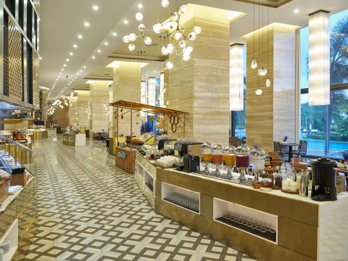 Breakfast buffet counters under pendant lights, with bread, fruit and a coffee station